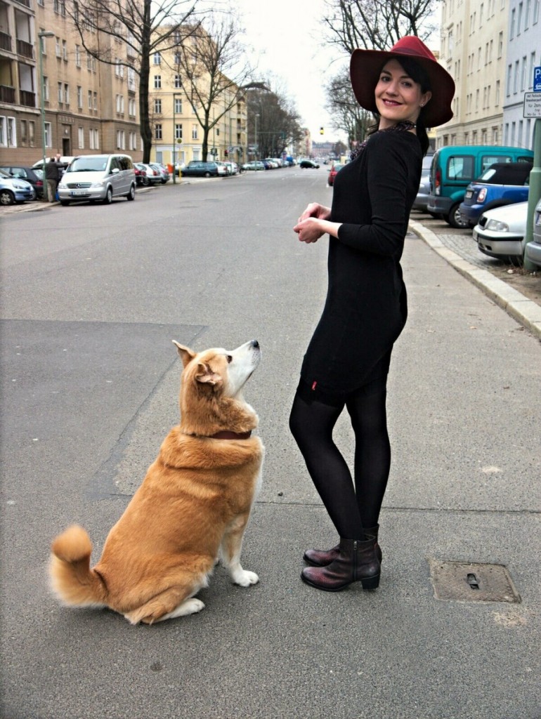 Akita and brunette in sweater dress and marsala fedora