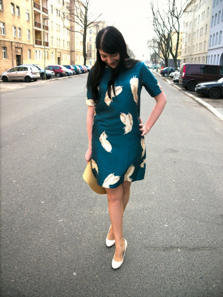 Brunette wearing Noa Noa seagreen dress with feather print