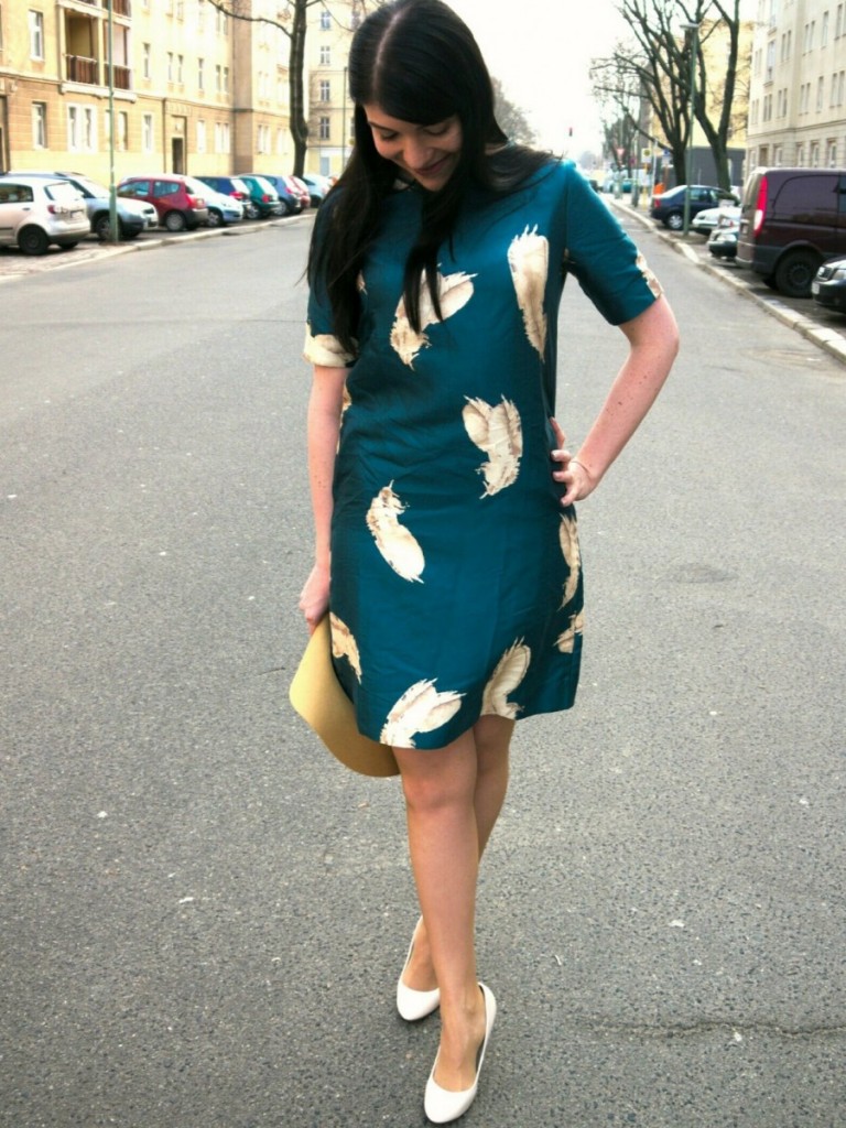 Brunette wearing Noa Noa seagreen dress with feather print