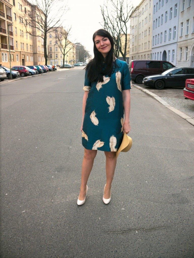 Brunette wearing Noa Noa seagreen dress with feather print