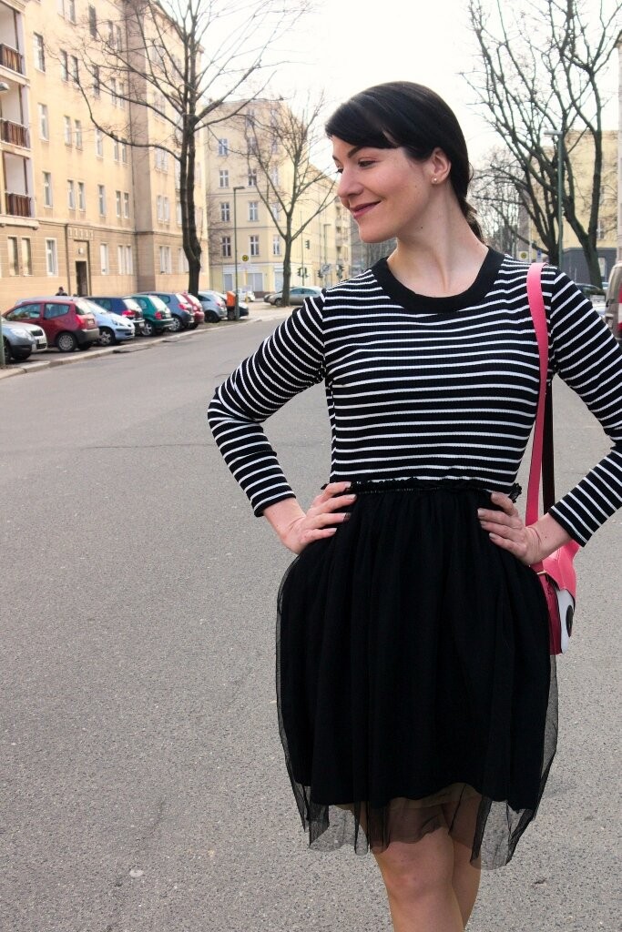 brunette_wearing_striped_pinup_dress_with_tulle_skirt_and_cute_pink_fox_bag_in_Berlin_street