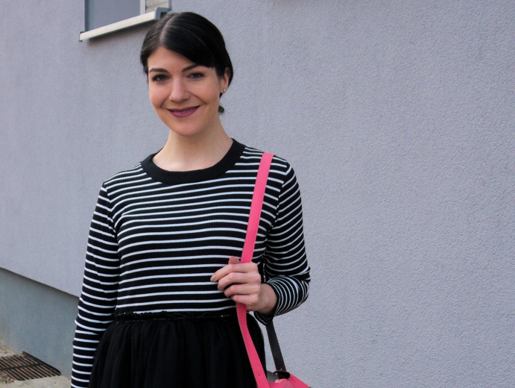 brunette_wearing_striped_pinup_dress_with_tulle_skirt_and_cute_pink_fox_bag_in_Berlin_street