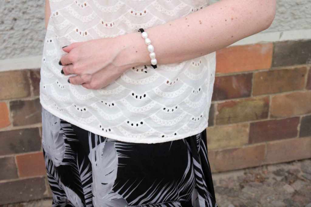 of shoulder blouse and pearl bracelet