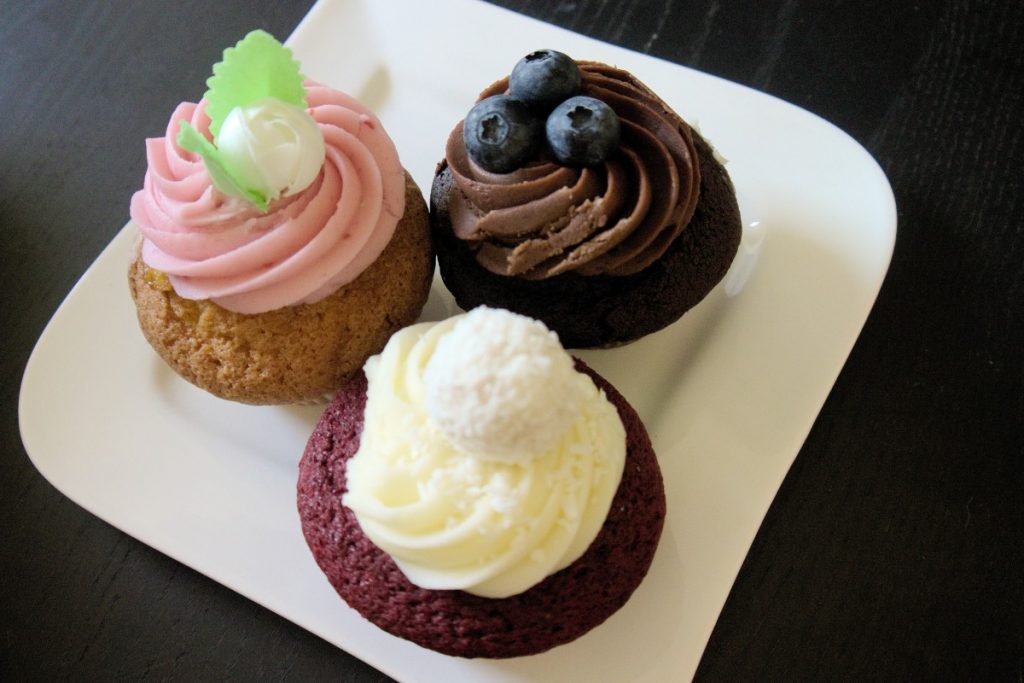 raspberry beret, chocolate lava and red velvet cupcakes with ornate decoration on a plate