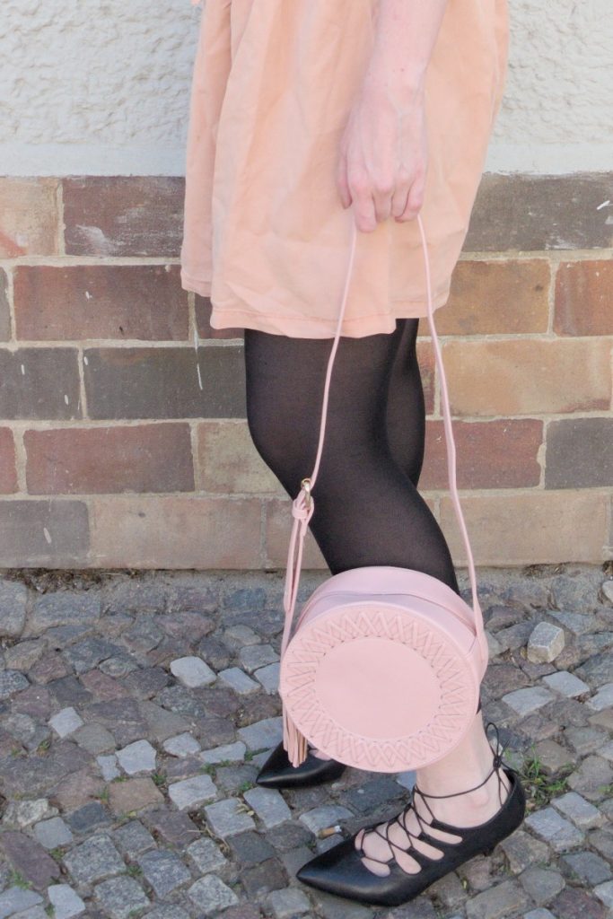 blush and black outfit with pink lyocell dress and round leather bag